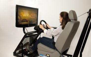 Chica realizando práctica en simulador de conducción Chica realizando práctica en simulador de conducción